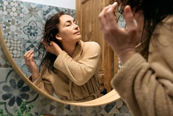 Woman checking hair in mirror